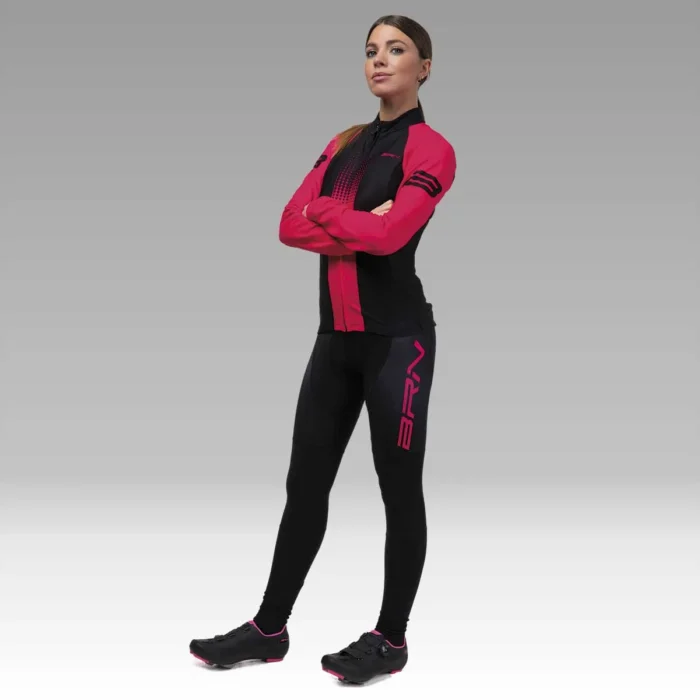 Ciclista donna posando con la maglia BRN a manica lunga e pantaloni neri, evidenziando il design sportivo.