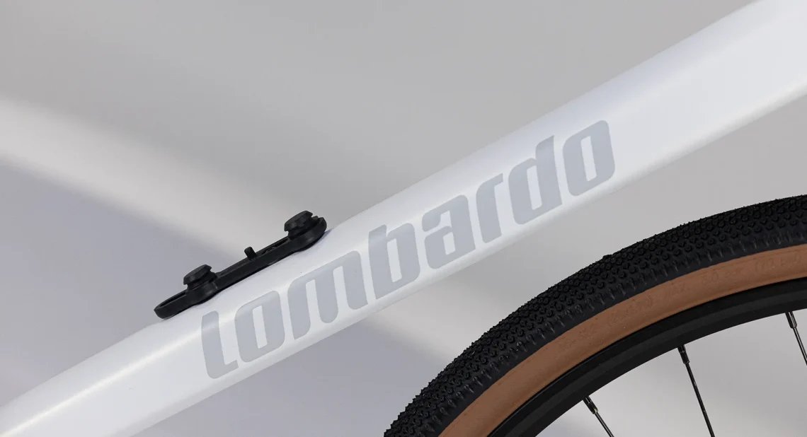 Dettaglio del telaio della bicicletta, con il logo 'Lombardo' in evidenza e il supporto per accessori, che mette in risalto il design pulito e funzionale della bicicletta.